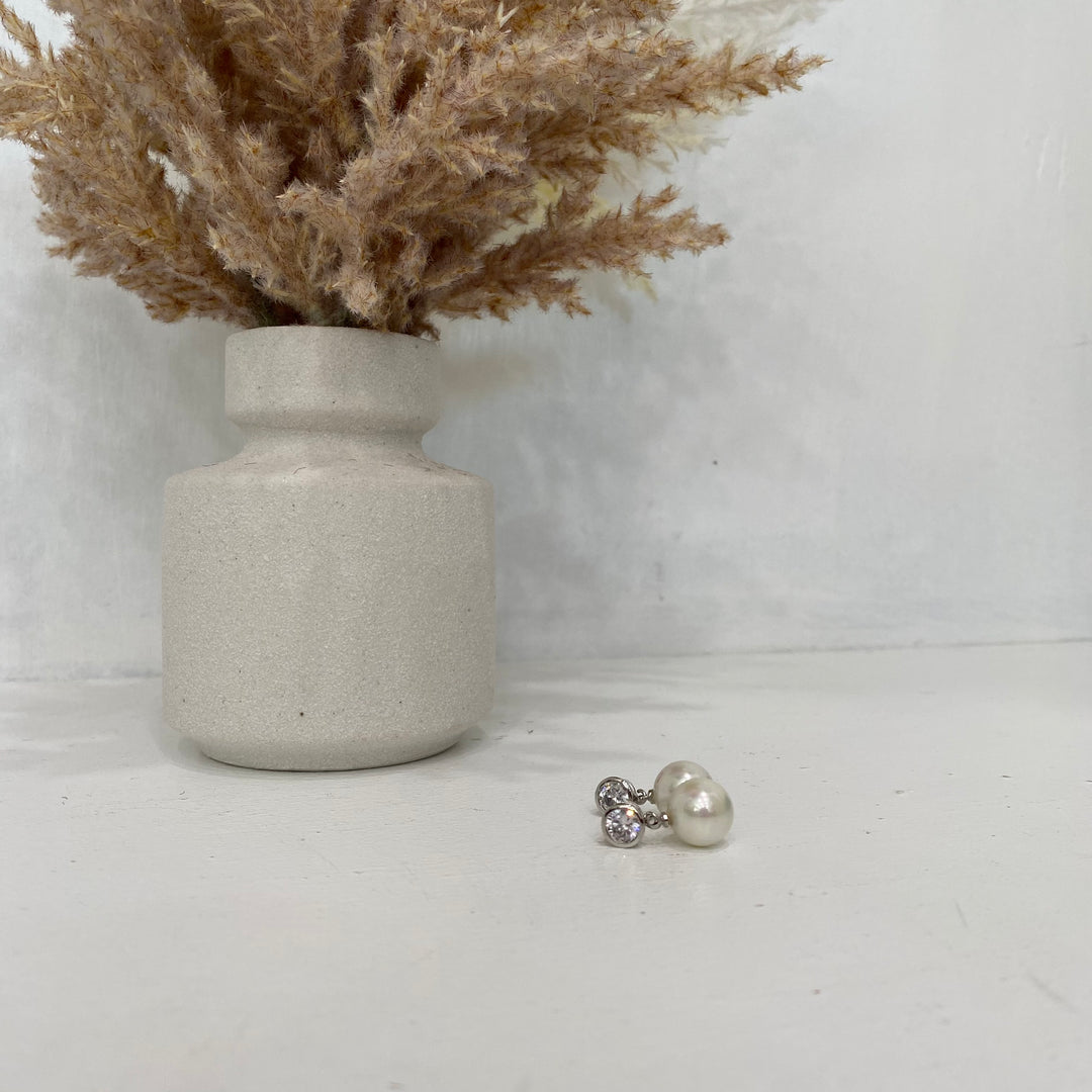 Boucle d'oreille en perles blanches avec clou en cristal